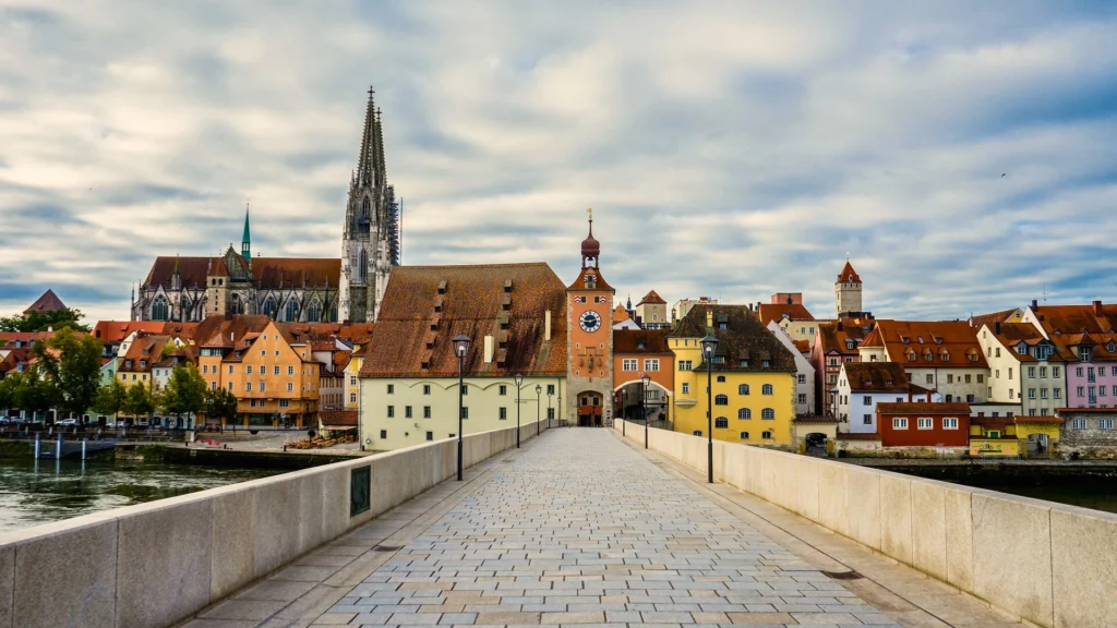 Picture of historic buildings along a riverbank. It represents a typical old German city with colorful buildings. Text: "Financial advice for expats in Germany"
