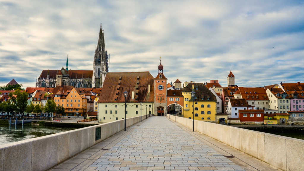 Picture of historic buildings along a riverbank. It represents a typical old German city with colorful buildings. Text: "Financial advice for expats in Germany"