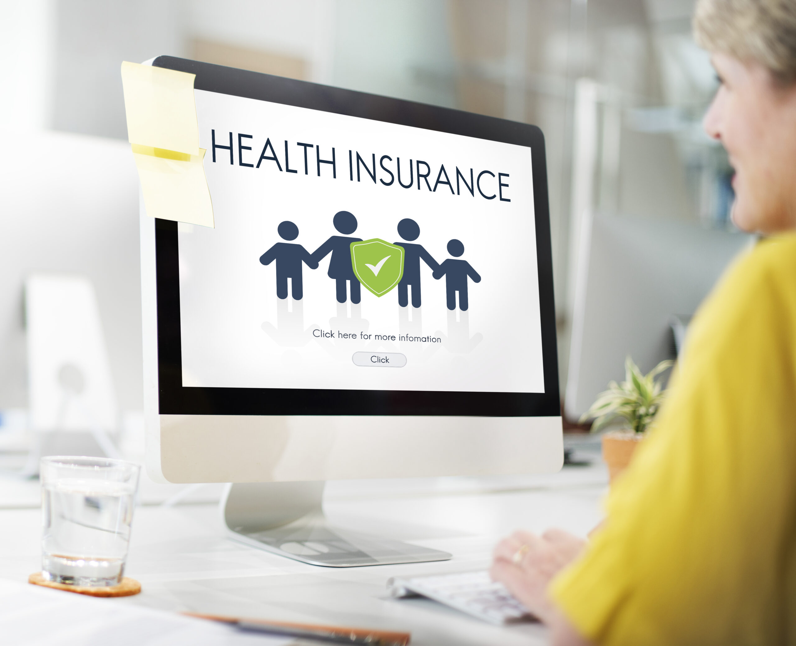 Women looking at a screen where it is written "Health Insurance: click here for more information"